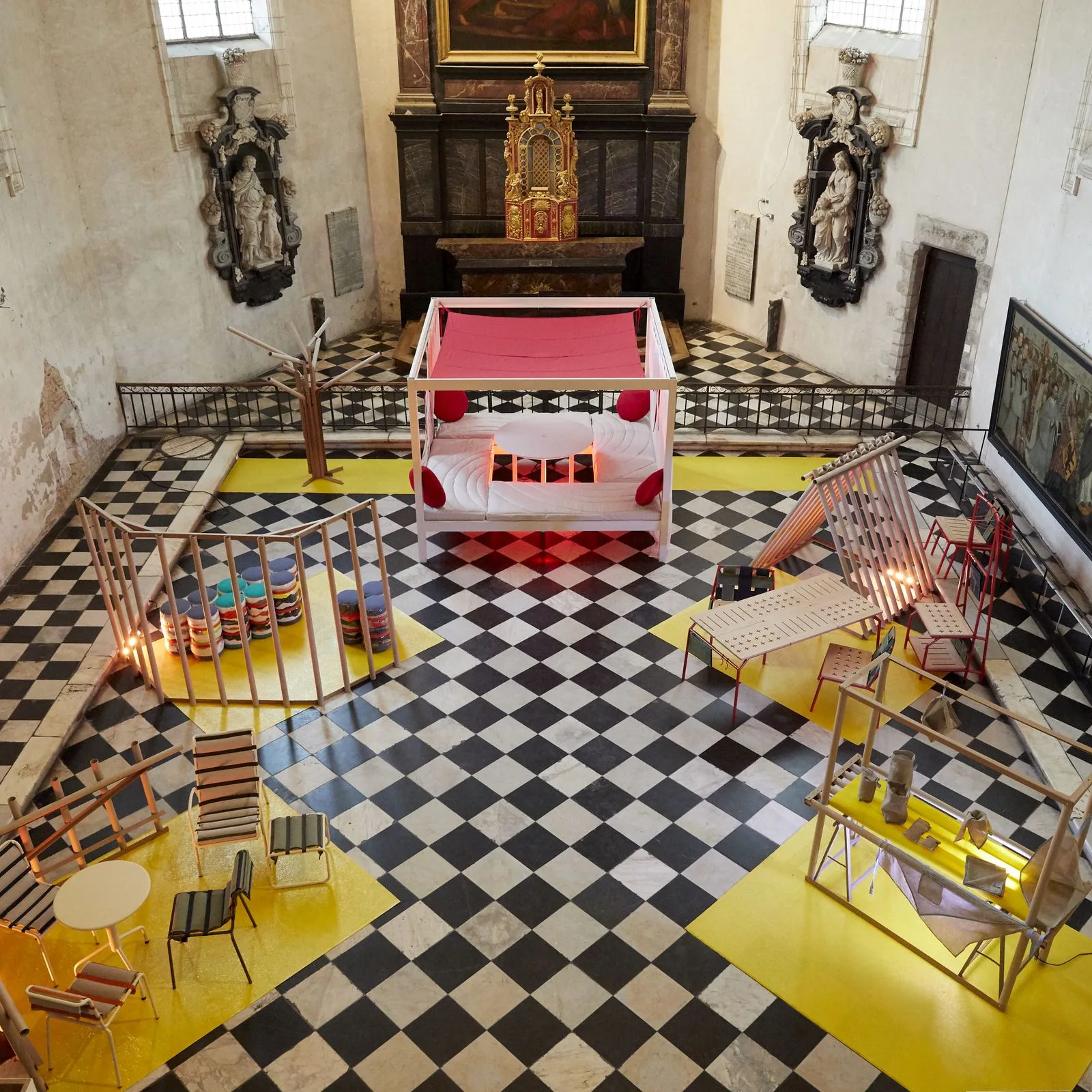 Vue plongeante de l'exposition finale de la 9e édition dans la chapelle de l'Hospice Comtesse : les six projets posés sur des tapis jaunes, sur le sol en damier.